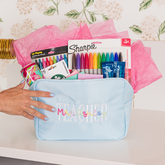 Teacher-themed personalized nylon filled with pens and school supplies, a thoughtful gift idea.