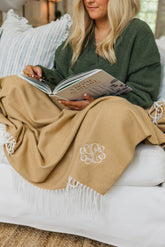 Woman relaxing under a cozy monogrammed blanket warm personalized gift.