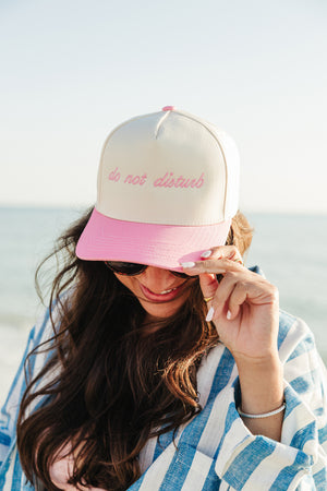 Beach-ready woman in pink vintage trucker hat with personalized embroidery.