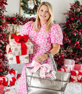 Woman holding personalized Christmas gifts including personalized puffer tote.