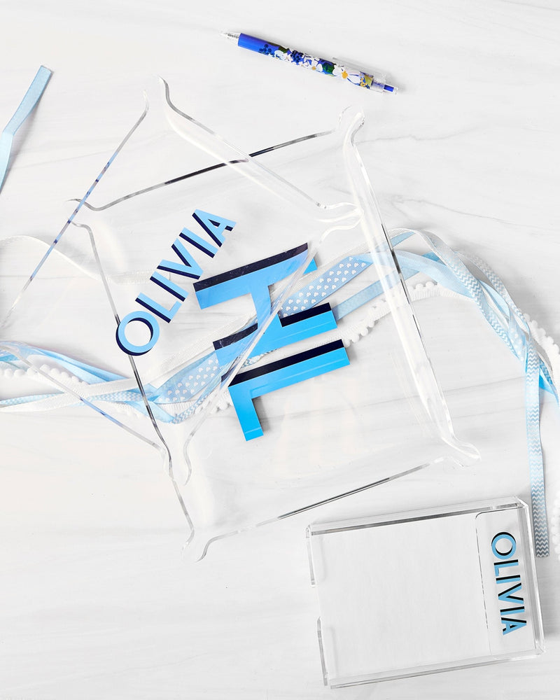 A notepad and a small and large acrylic tray are all customized with blue personalization.