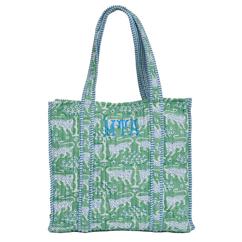 Green block print quilted tote bag with striped straps, monogrammed 'MTA' in blue, on a white background.