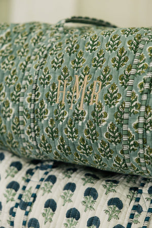 Green embroidered block print duffel with monogram detail, perfect for personalized travel style.
