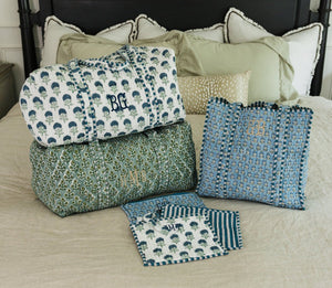 Personalized embroidered block print duffel and tote bag set in blue and green patterns, styled on a bed.