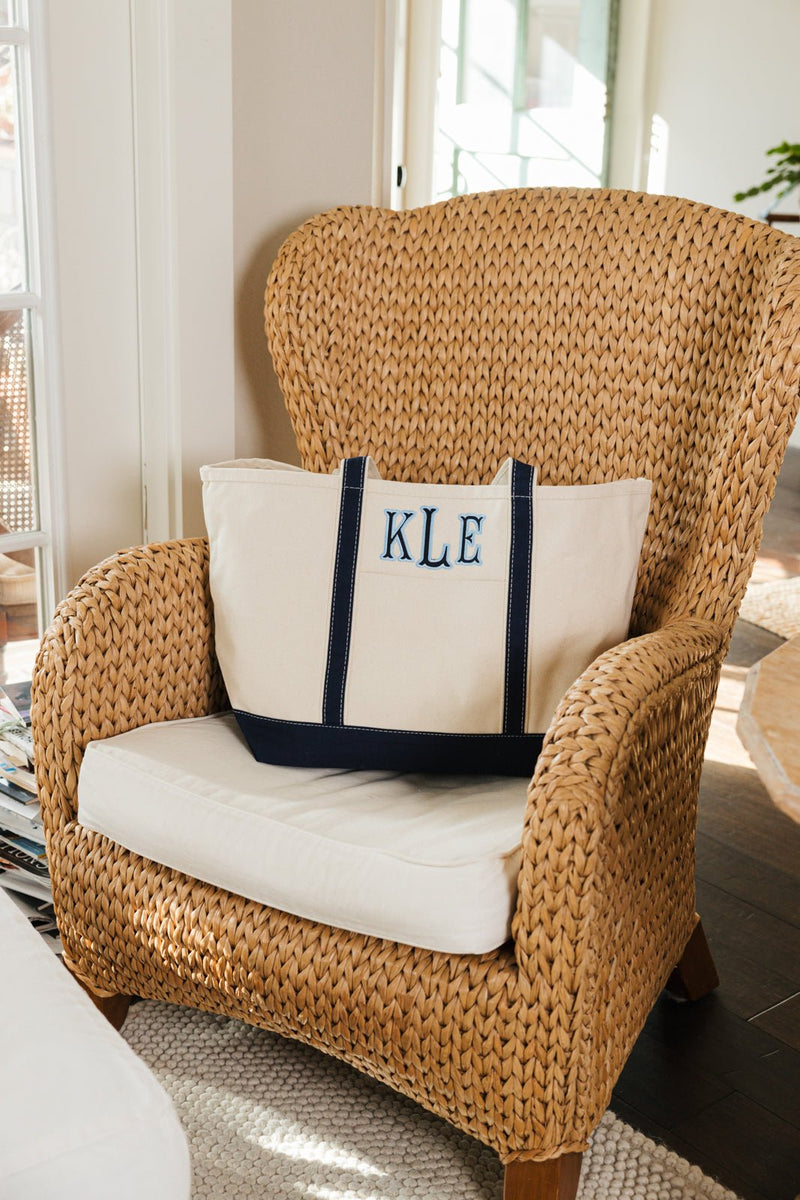Black embroidered canvas tote with applique personalization, versatile use.