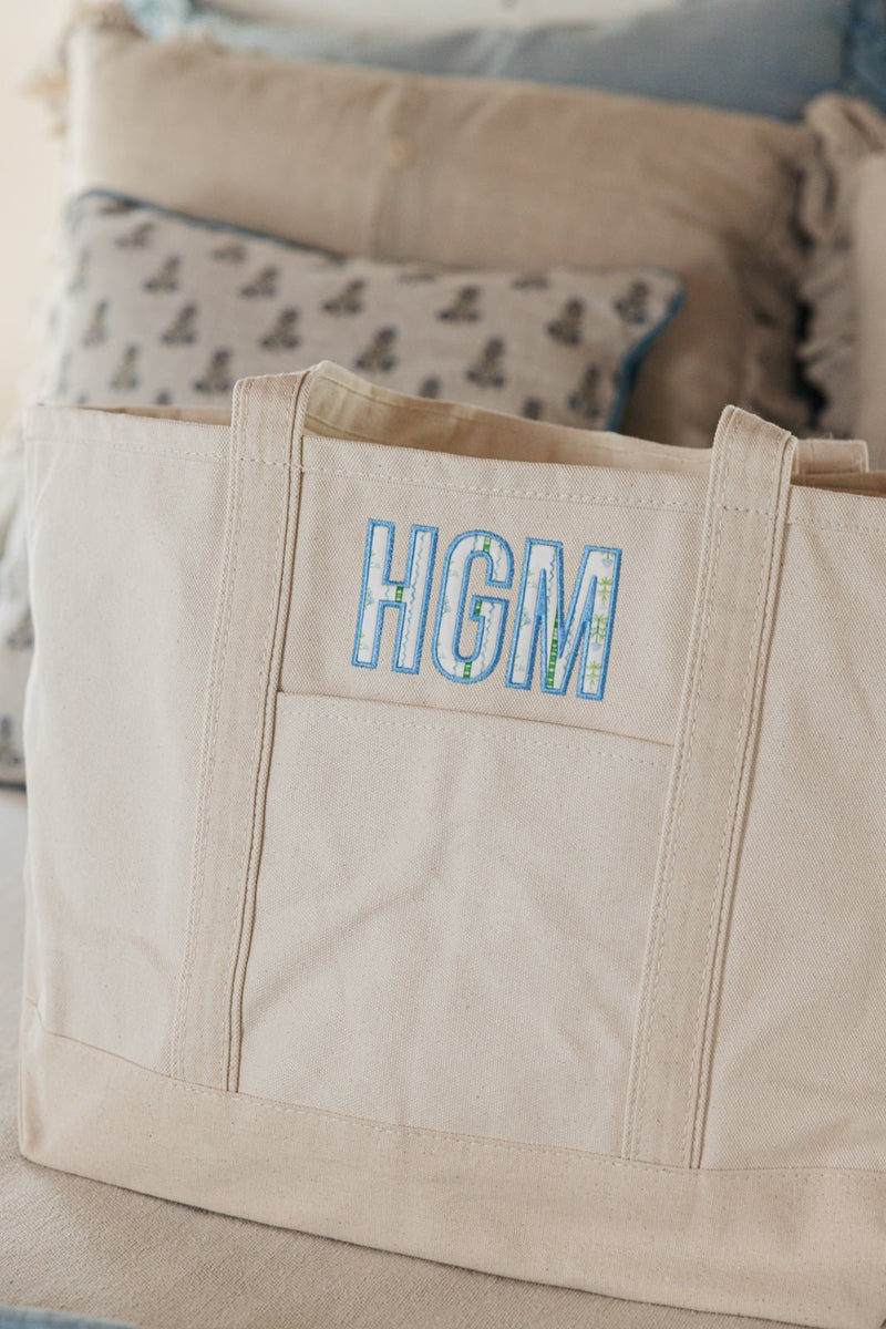 Large neutral canvas tote with applique initials, stylish and durable.