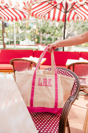 Pink embroidered canvas tote with applique initials, great for gifting.