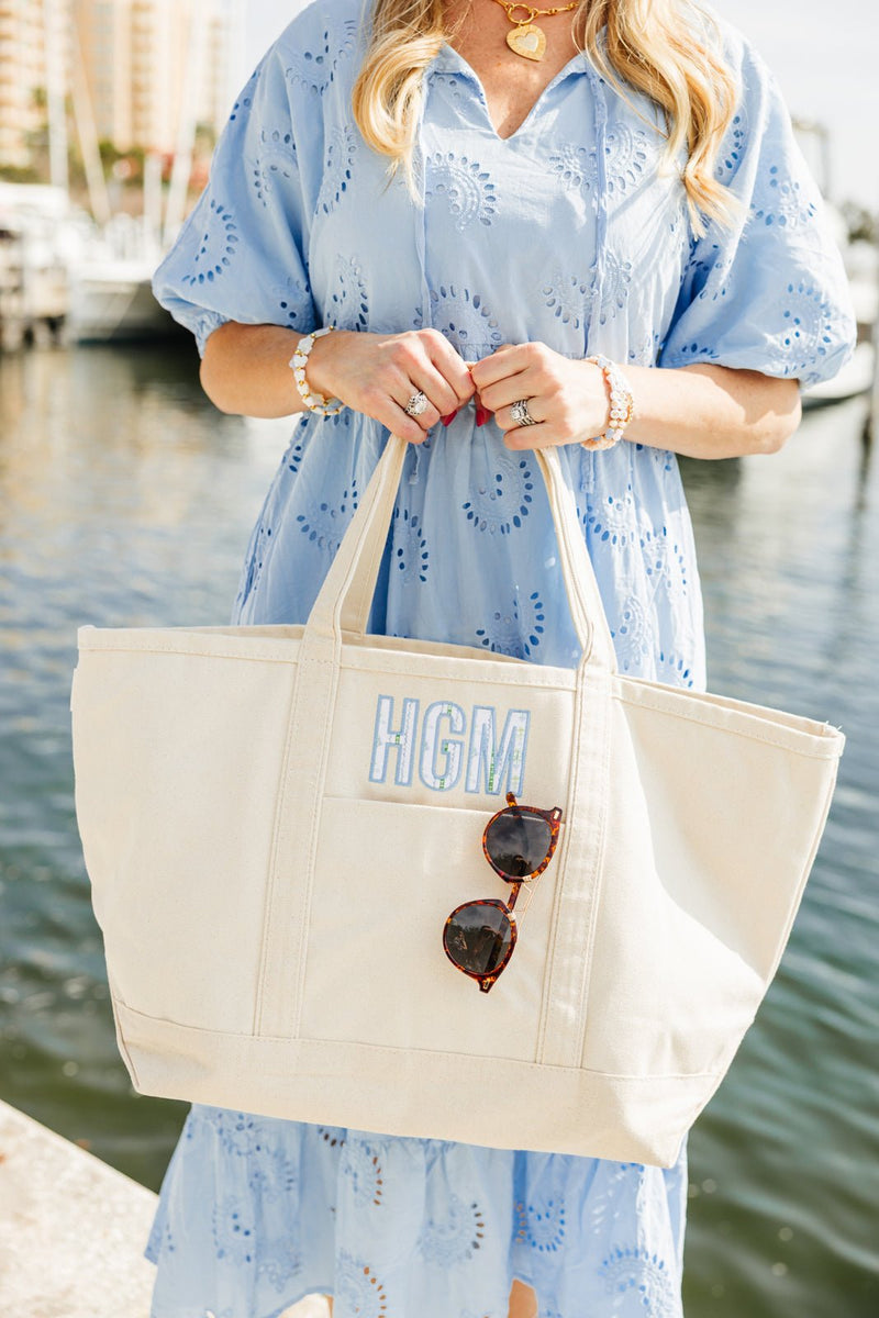 Neutral embroidered canvas tote bag with applique personalization.