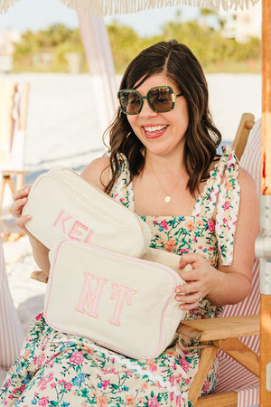 Woman holding embroidered extra large canvas pouch with applique monogram.