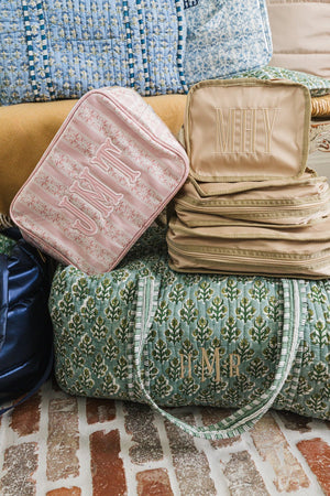 Embroidered Block Print Duffel with personalized monogram, styled beside matching travel accessories.