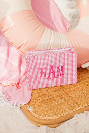 A pink roadie is customized with a pink monogram and is placed on the beach.