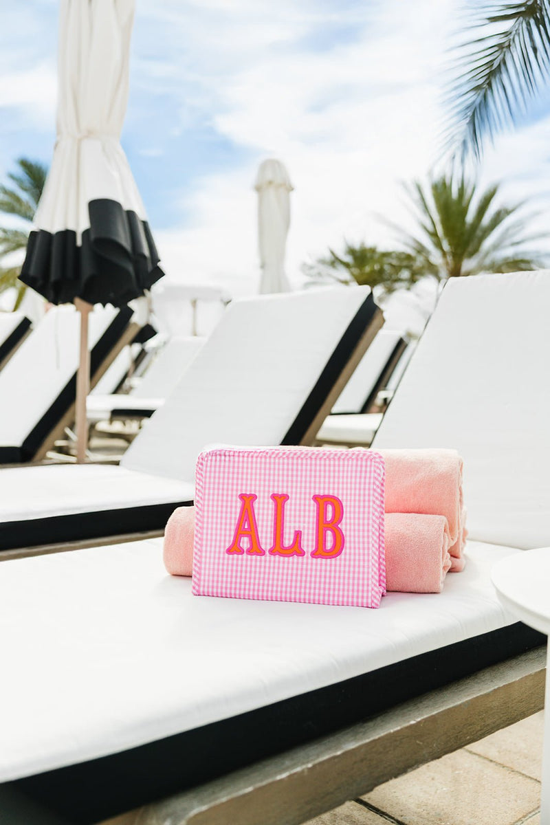 Monogrammed TRVL Roadie applique pouch styled outdoors with ALB initials.
