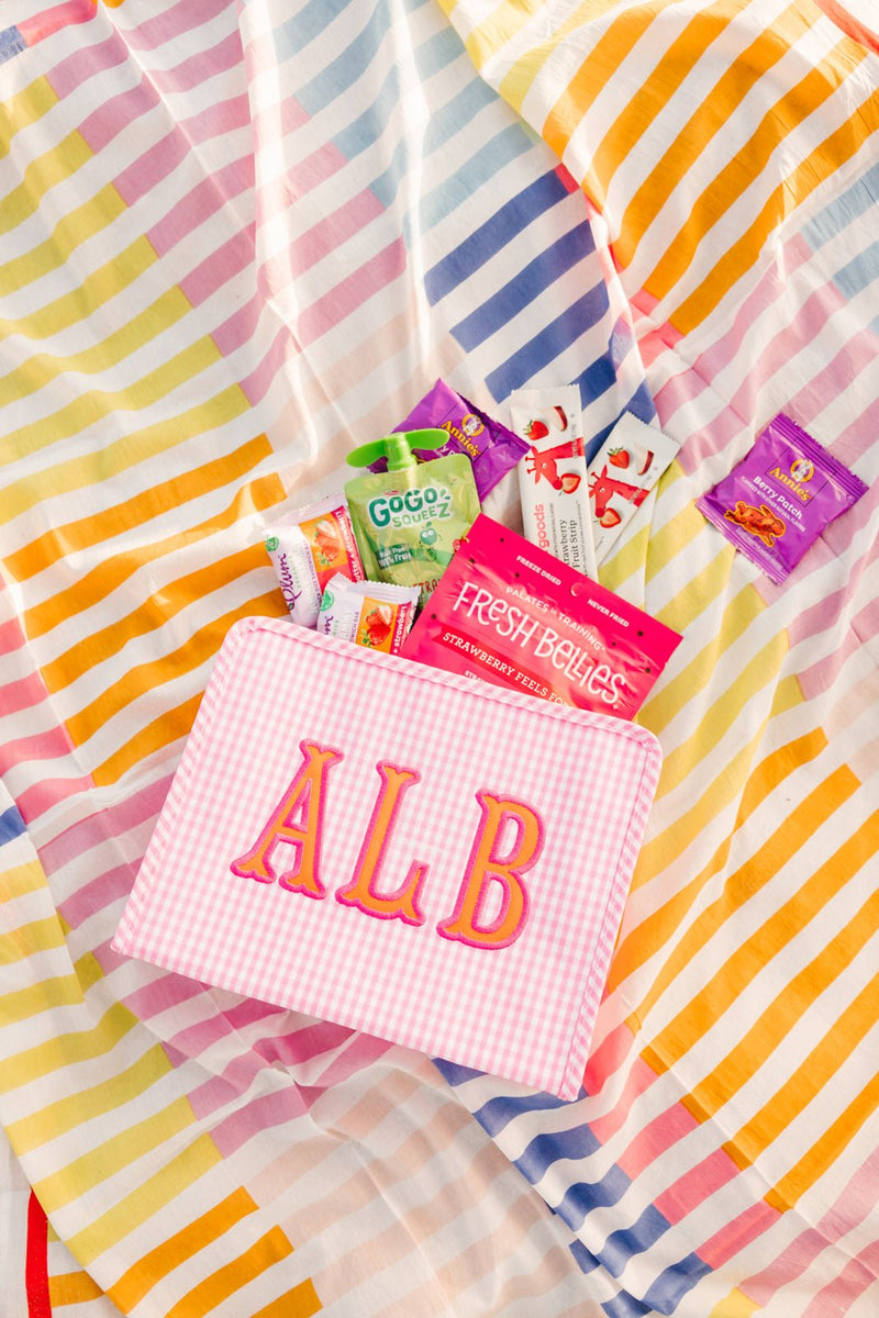 Close-up of embroidered TRVL Roadie pouch with pink applique initials ALB.