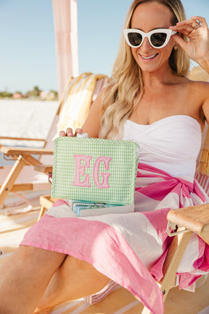Stylish beach flat lay featuring embroidered TRVL Roadie applique bag.