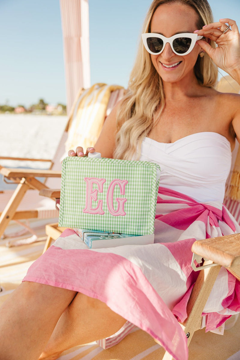 Stylish beach flat lay featuring embroidered TRVL Roadie applique bag.
