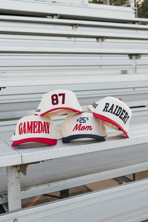 Trio on bleachers: Featuring the red-brim “GAMEDAY” cap styled with team.hats