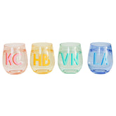 A pink, yellow, green, and a blue wine glass are personalized with different colored monograms.