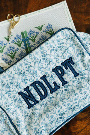 Blue floral Needlepoint XL Project Pouch with embroidered text, ideal for crafting and storage.