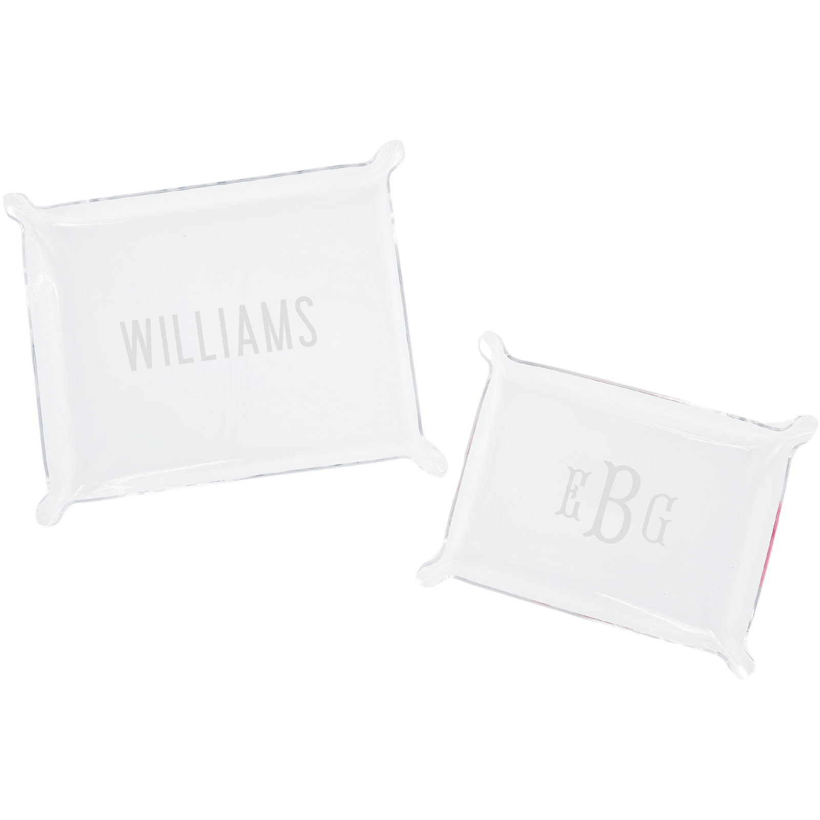 A set of two personalized acrylic trays featuring elegant monogrammed designs—one with the name 'WILLIAMS' and the other with initials 'EBG.' These chic and versatile catch-all trays add a stylish touch to any space, perfect for organizing small essentials on a desk, dresser, or entryway. Pair them with other custom acrylic accessories for a coordinated look