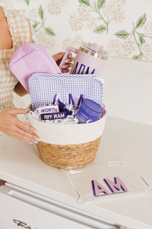 Purple-themed personalized gift basket featuring embroidered travel pouch, tumbler, and acrylic tray.