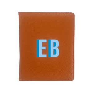 A luxurious tan leather passport holder personalized with the initials 'EB' in bold blue font. This elegant travel essential is part of a coordinated travel set, perfect for organized and stylish jet-setters. The premium pebbled leather texture adds a sophisticated touch, making it a must-have for frequent travelers who love a personal touch in their accessories.