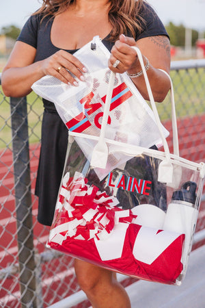 Woman carrying red and white striped monogram pool bag filled with picnic items