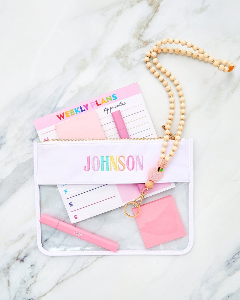 Embroidered Teacher Nylon Clear Pouch – @PBANDJ4THGRADE x SWP in clear nylon with lavender trim and multicolor “Johnson” embroidery, styled with weekly-plans notepad, pastel pens, and beaded lanyard