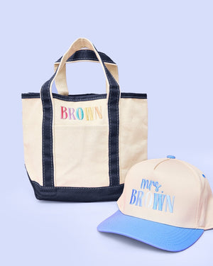 Teacher Tote & Hat Bundle – @PBANDJ4THGRADE x SWP: natural canvas tote with navy-blue trim personalized “Brown” and matching trucker hat with sky-blue brim “Mrs. Brown” embroidery