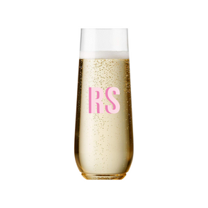 A champagne flute is customized with a pink shadow monogram