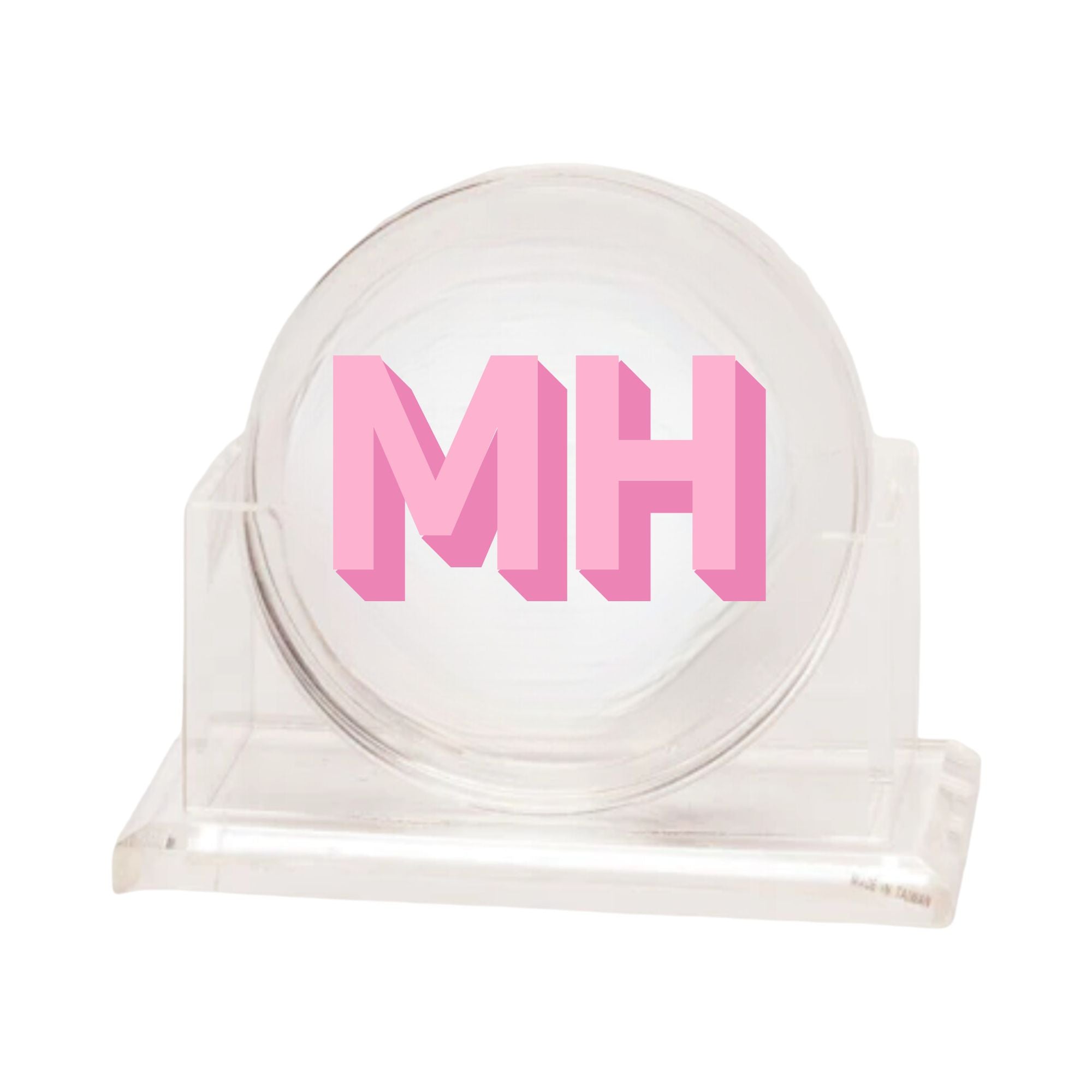 A set of coasters sits in a holder showing off it's custom pink monogram.