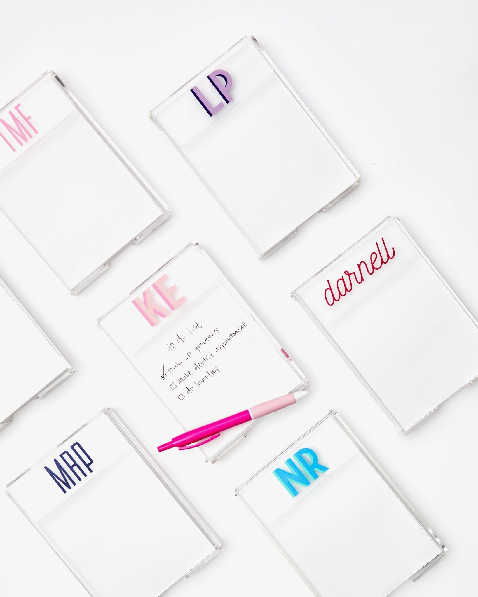 A clear acrylic notepad customized with initials