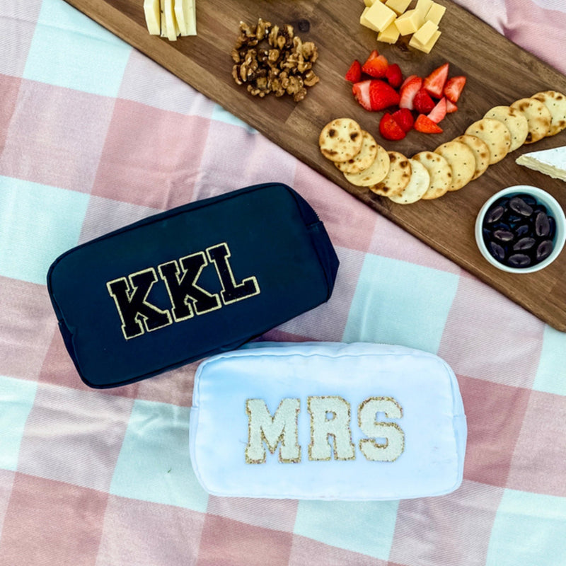 A black and white nylon pouch are customized with chenille patch letters.