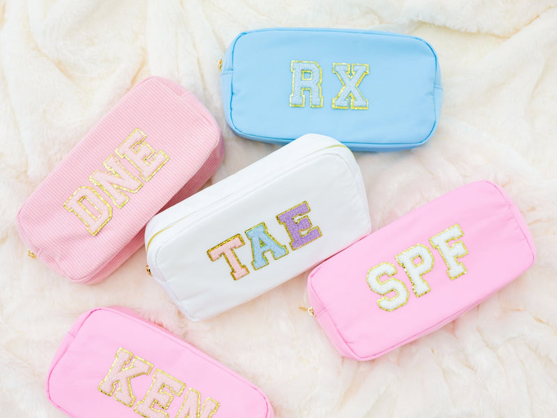 A group of nylon pouches are customized with chenille patches in different colors.