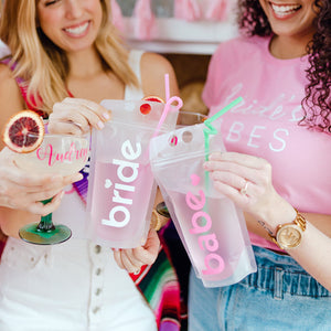 A group of women cheers each other with their doll-themed party pouches