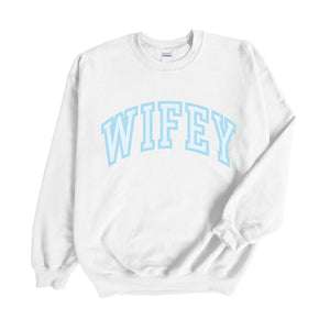 A white sweatshirt with "Wifey" written on the front in blue