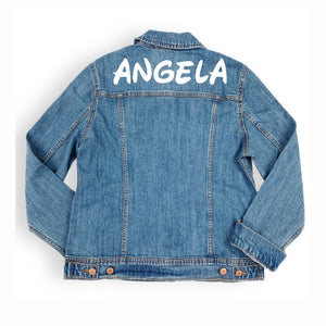 A denim jacket is customized with a name across the shoulders in a white font.