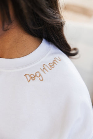 Close-up of embroidered collar detail on custom white t-shirt with minimalist personalization