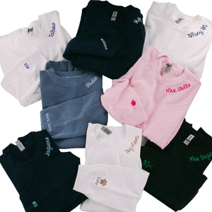 A pile of sweatshirts with embroidered collars and cuffs