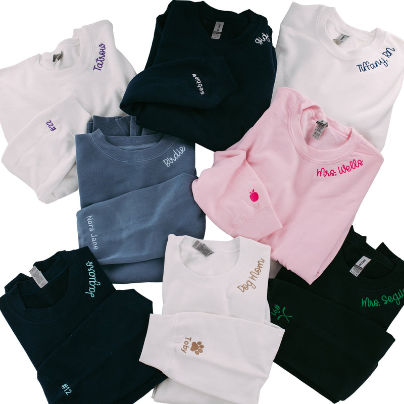 A pile of sweatshirts with embroidered collars and cuffs