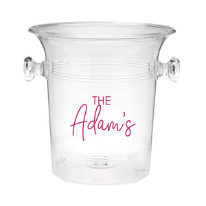 A clear ice bucket with "The Adam's" on the front