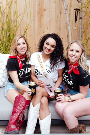 A trio of women celebrate a bachelorette party with a western theme