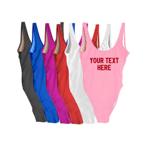 A group of swimsuits are laid out to show that they can be customized with any text