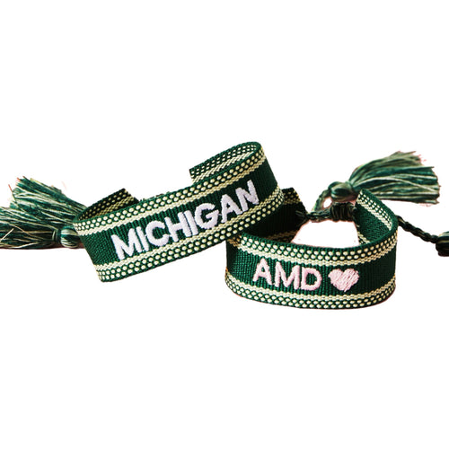 Embroidered bracelet with motif displayed on green background