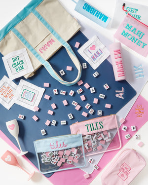 Flat lay of embroidered mahjong canvas tote with coordinating mahjong accessories