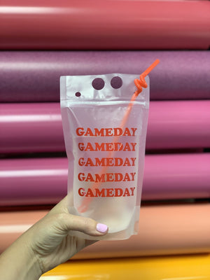 A person holds up a party pouch which reads "Gameday" in orange.