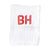 A white guest towel with "BH" embroidered in pink and orange