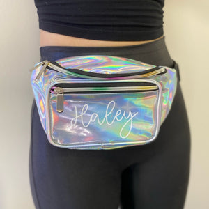A silver metallic fanny pack is customized with script white name