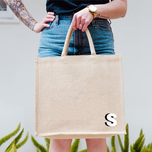 A jute tote with a "S" monogrammed on the bottom corner