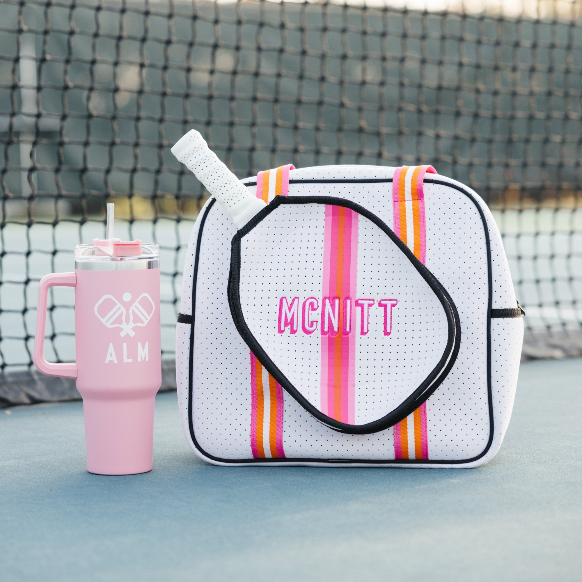 A group of pickleball bags are customized with colorful embroidered monograms and names