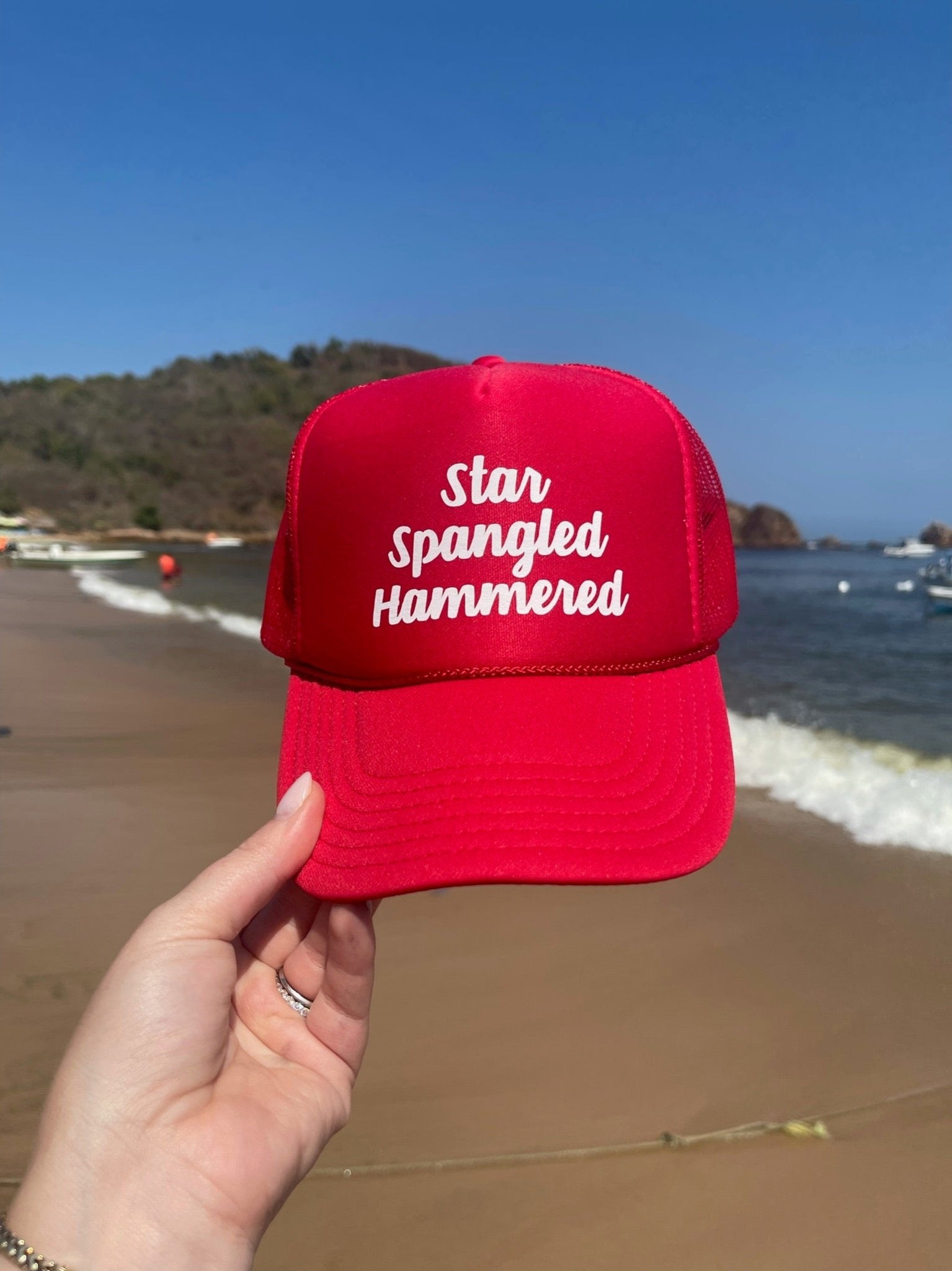 A red trucker hat reads "Star Spangled Hammered" in white script